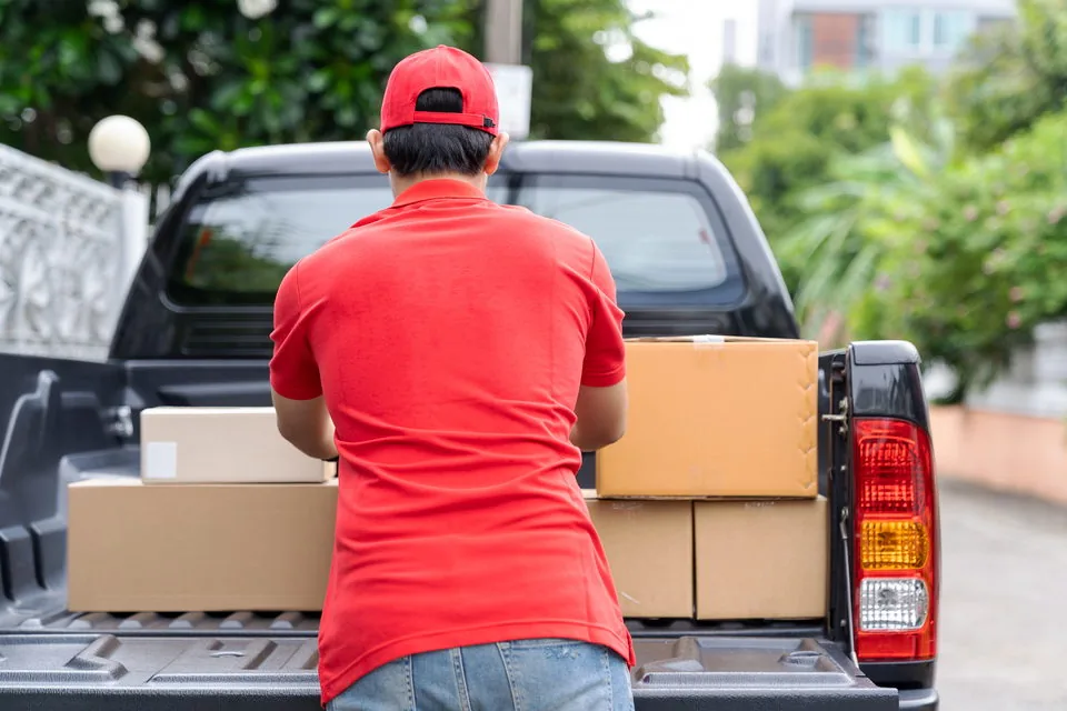 Operator loading boxes into the bed of his pickup
